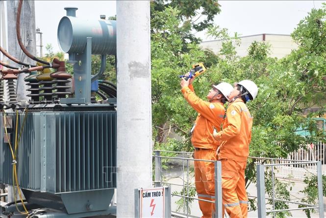 Công nhân EVNHANOI kiểm tra trạm biến áp nhằm phát hiện sớn các nguy cơ phát sinh sự cố, đặc biệt là các điểm phát nhiệt bất thường có thể dẫn đến quá tải hoặc cháy nổ thiết bị điện. (Ảnh: Quốc Lũy/TTXVN)